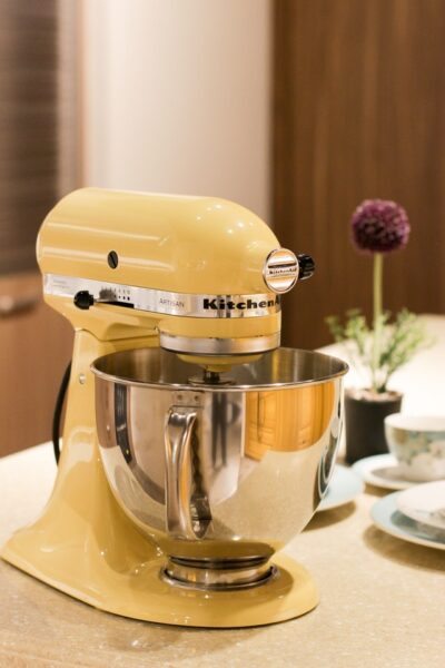 Auf einer Küchenarbeitsfläche steht eine gelbe Kitchen Aid Küchenmaschine