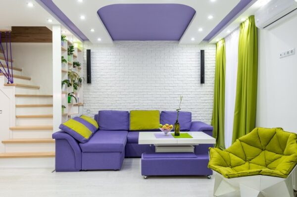 Eine Couch-Garnitur sowie Zimmerdecke ist in Very Peri gefärbt.