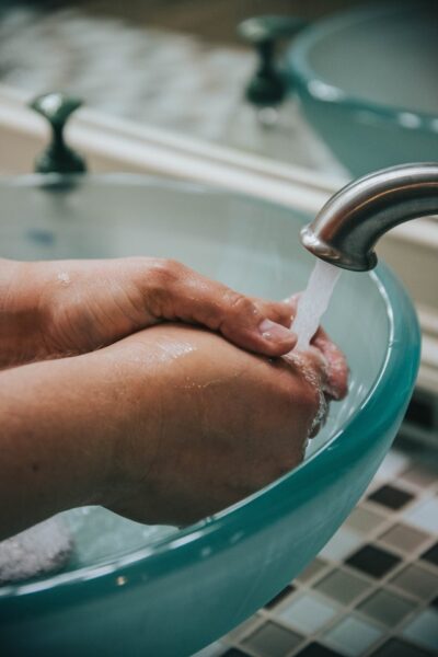 Eine Person wäscht sich an einem Waschbecken die Hände.