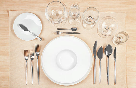 Besteck, Geschirr und Gläser richtig auf einem Tisch angeordnet.